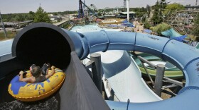 Josh Bingham begins riding down a waterslide, with roller coasters visible in the distance, in the Hurricane Hannah section of Geauga Lake Park in Aurora, Ohio. 