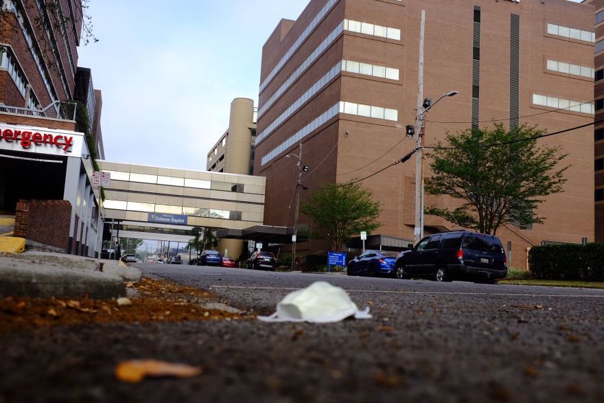 A discarded face mask lies on the ground outside Ochsner Baptist Medical Center in New Orleans. March 25, 2020.