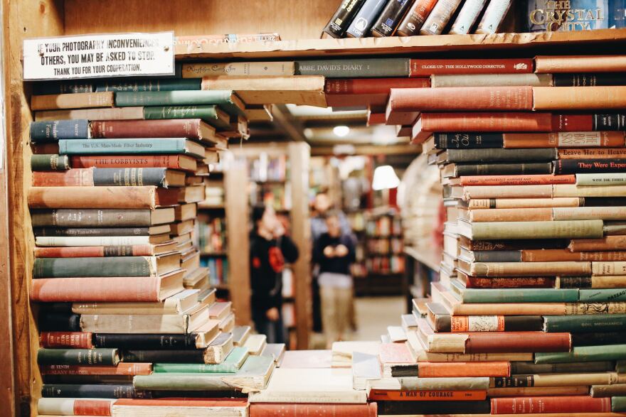 Looking through books on a library bookshelf.