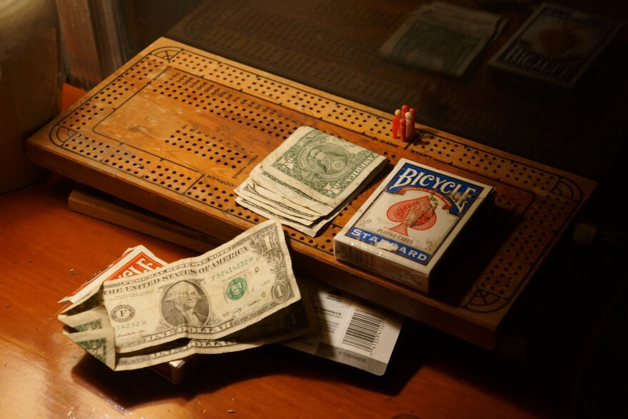 Cribbage board and a pack of cards and some loose dollar bills
