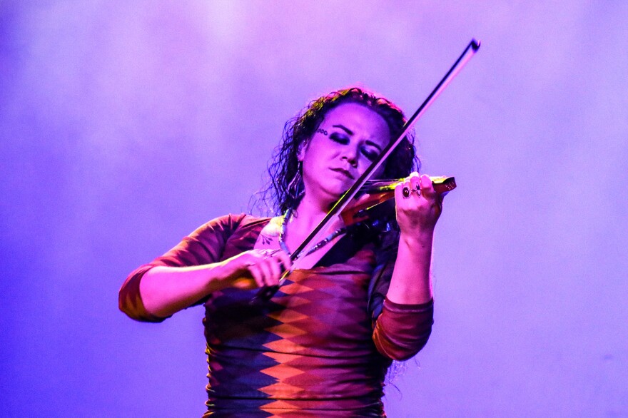 A female violinist plays with her eyes closed.