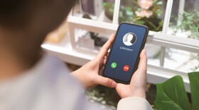 Woman holding mobile phone with incoming call from unknown caller. 