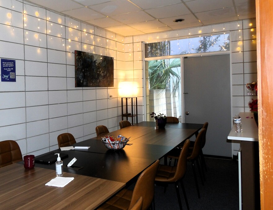 A neat conference room with brown tables and white walls