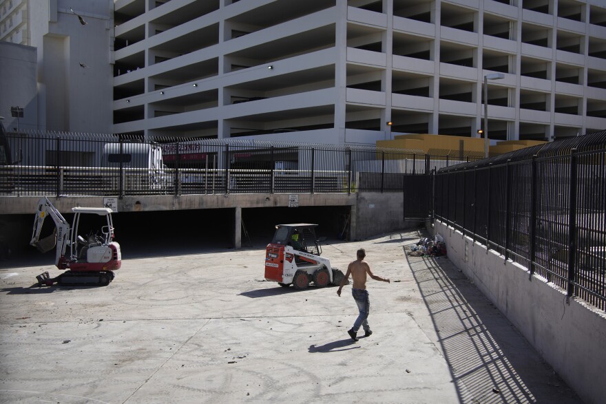 A homeless man watches as workers clear a homeless encampment in a storm drain near a casino in Las Vegas on Thursday, May 26, 2022. Hundreds of homeless people die in the streets each year from the heat, in cities around the U.S. and the world. The ranks of homeless have swelled after the pandemic and temperatures fueled by climate change soar. (AP Photo/John Locher)