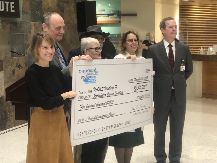 Officials with the Children's Tumor Foundation and the University of Arkansas for Medical Sciences pose with a ceremonial check for a $500,000 donation to the UAMS Adult Neurofibromatosis Clinic.