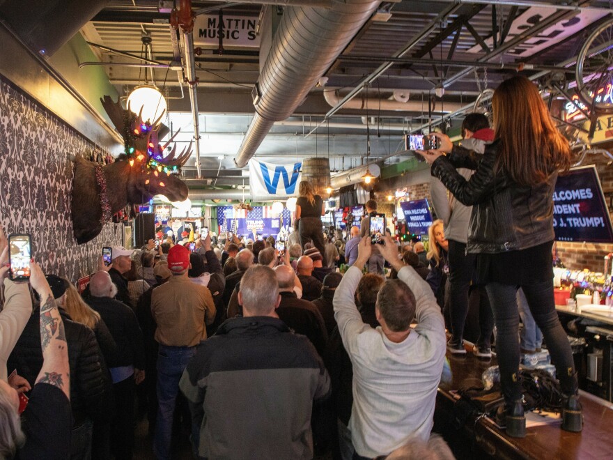 Supporters of former President Donald Trump stand on the bar at Whiskey River in Ankeny, Iowa to get a look at him as he campaigns for the Republican presidential nomination in 2024.