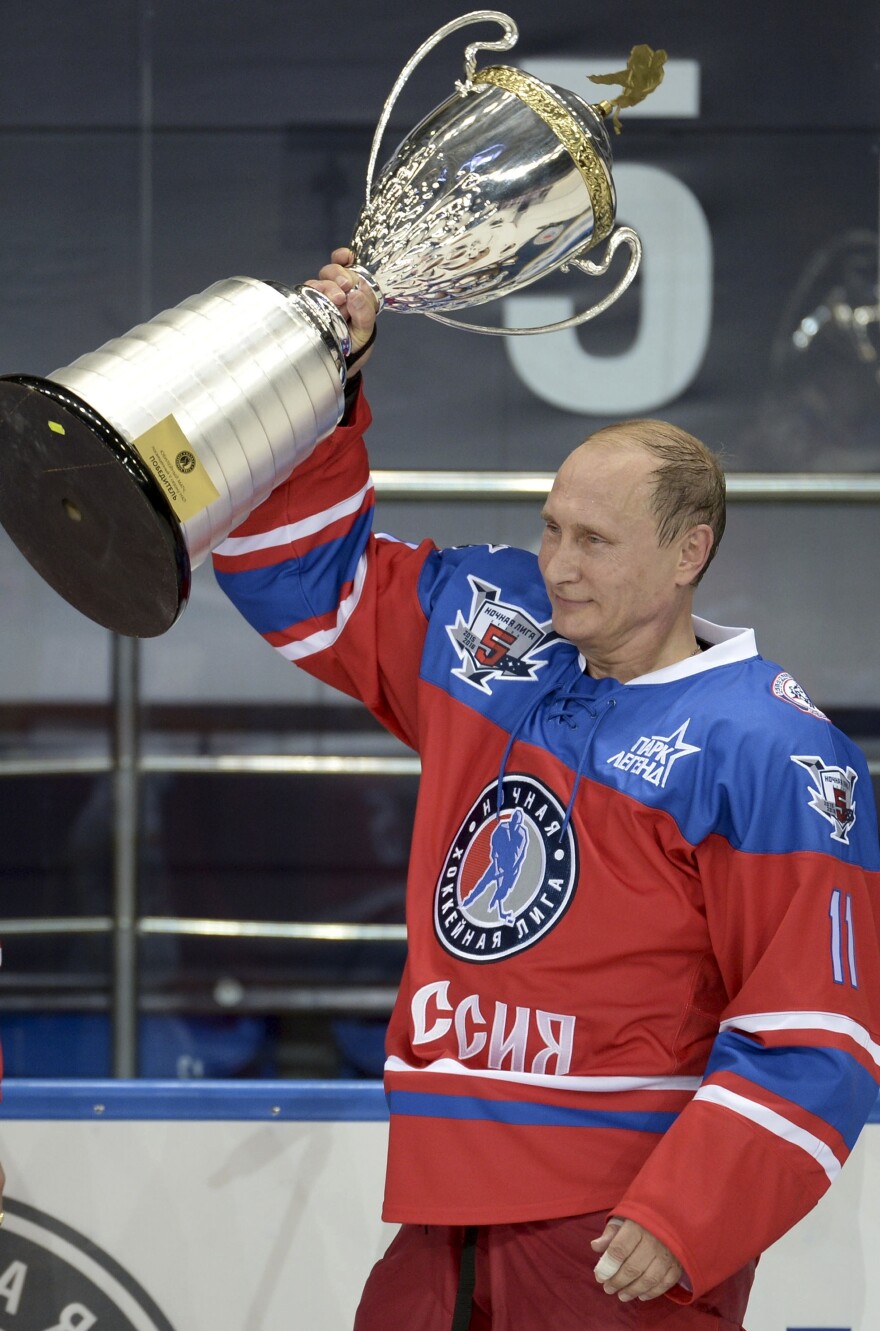 Putin holds a trophy at his birthday hockey match, during which he scored seven goals.