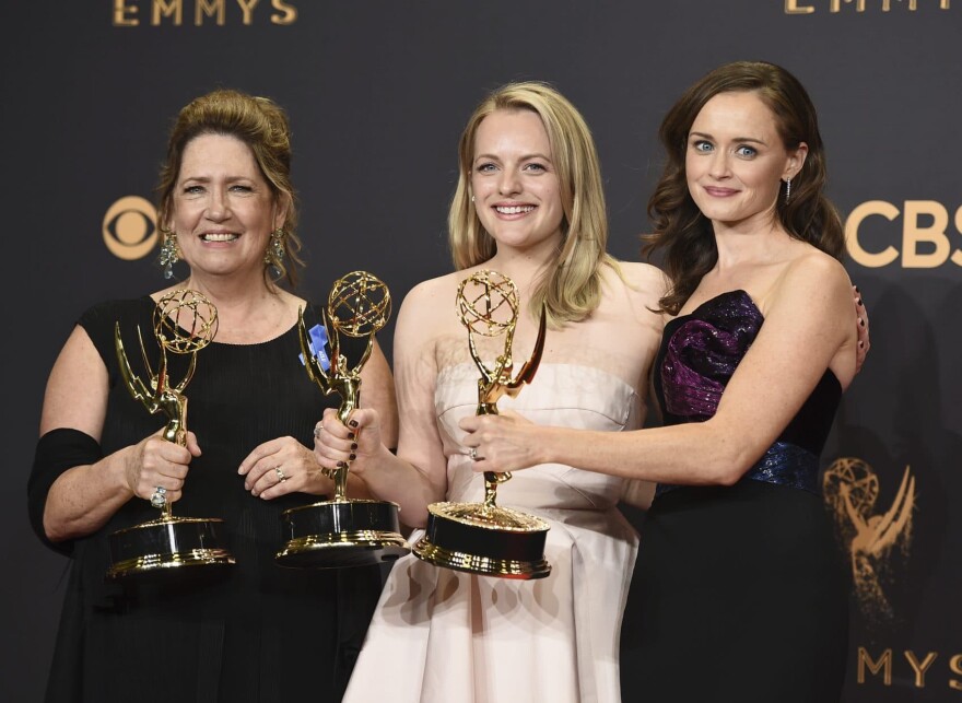 Ann Dowd, from left, winner of outstanding supporting actress in a drama series, Elisabeth Moss, winner of outstanding lead actress in a drama series, and Alexis Bledel, winner of outstanding guest actress in a drama for "The Handmaid's Tale" pose in the press room at the 69th Primetime Emmy Awards on Sunday, Sept. 17, 2017, at the Microsoft Theater in Los Angeles. (Jordan Strauss/Invision/AP)