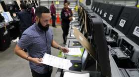 Employees test voting equipment at the Miami-Dade County Elections Department, Wednesday, Oct. 19, 2022, in Miami, in advance of the 2022 midterm elections on Nov. 8. (AP Photo/Lynne Sladky)