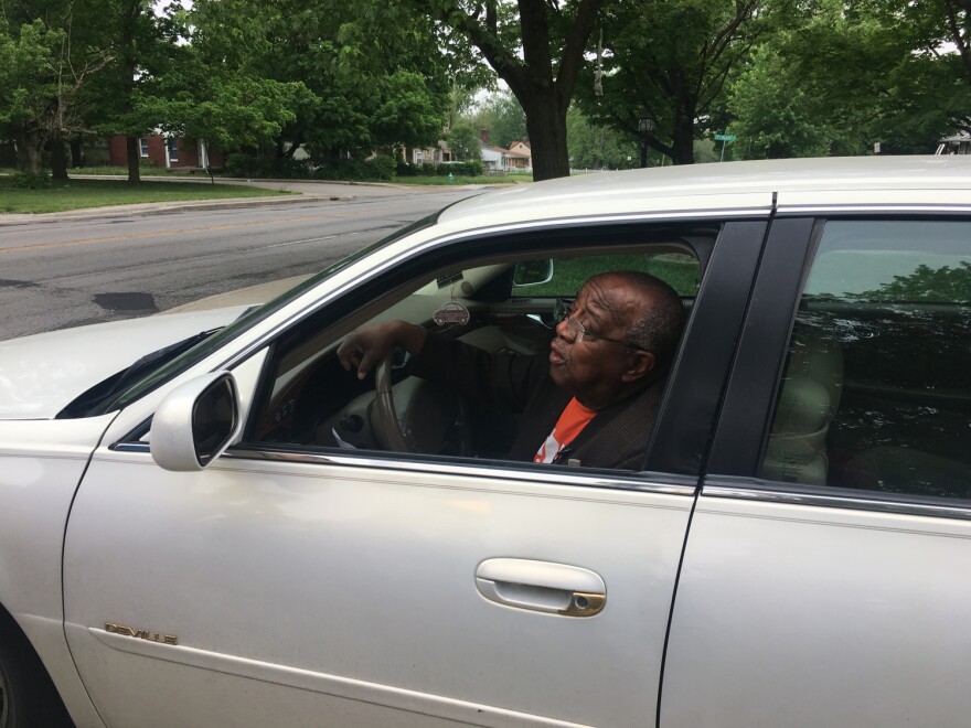 Indianapolis City-County Councilor William Oliver demonstrated reaching for a cell phone and registration in his car during a press conference outside his home.