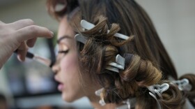 A stylist does the make-up of Sofia Salomon at her home in preparation for a television program interview in Caracas, Venezuela, Tuesday, May 30, 2023.
