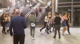 This image shows people running through Manchester Victoria station after an explosion at Manchester Arena. in Manchester England, Monday May 22, 2017. An apparent suicide bomber set off an improvised explosive device that killed over a dozen people at the end of an Ariana Grande concert on Monday, Manchester police said Tuesday May 23, 2017.  The station is very near the arena. (Zach Bruce/PA via AP)