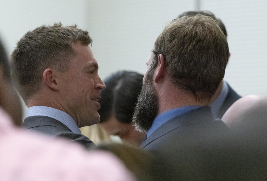 Defense attorney Casey Arbenz, left, smiles at his client, Matthew Collins, after Pierce County Superior Court Judge Bryan Chushcoff reads the jury's verdict and he is declared not guilty in the killing of Manny Ellis. All three Tacoma police officers, Timothy Rankine, Christopher "Shane" Burbank and Collins were found not guilty Thursday, December 21, 2023.