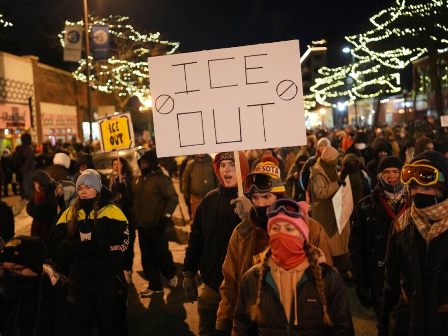 A person holds a sign during a vigil for 37-year-old Alex Pretti, who was fatally shot by a U.S. Border Patrol officer earlier in the day on Saturday in Minneapolis.