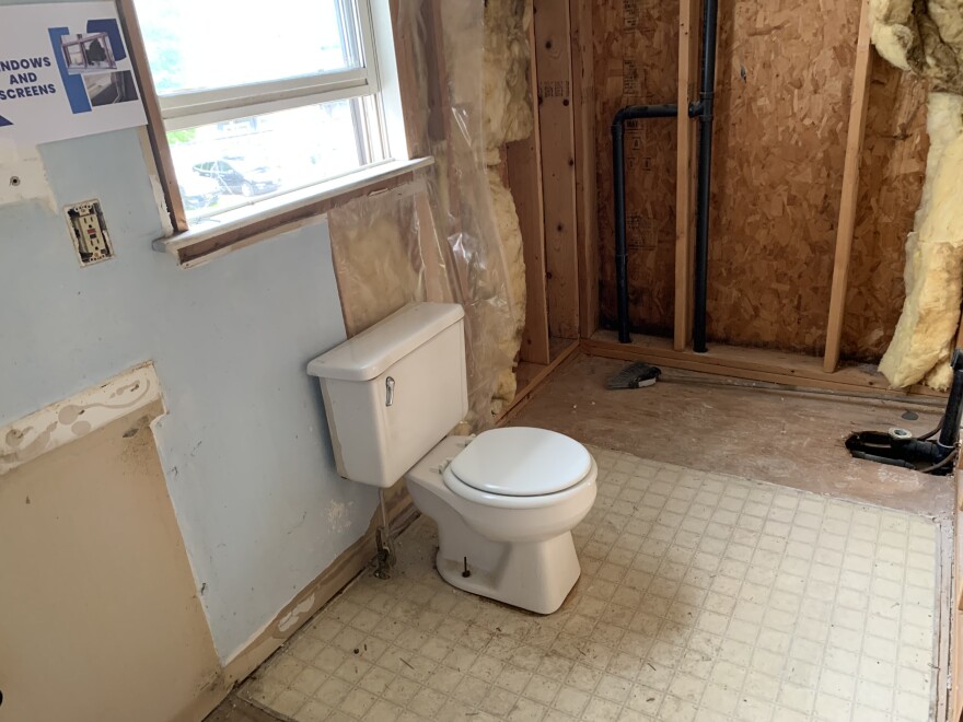 A bathroom lacking finished wall infrastructure violates housing code violations.