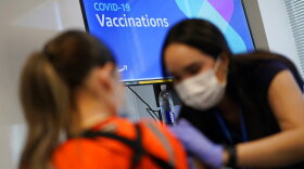 Registered nurse Sofia Mercado administers a COVID-19 vaccine at a vaccination event for workers at an Amazon fulfillment center in North Las Vegas.