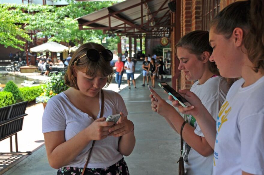 three teenage girls plays Pokemon GO