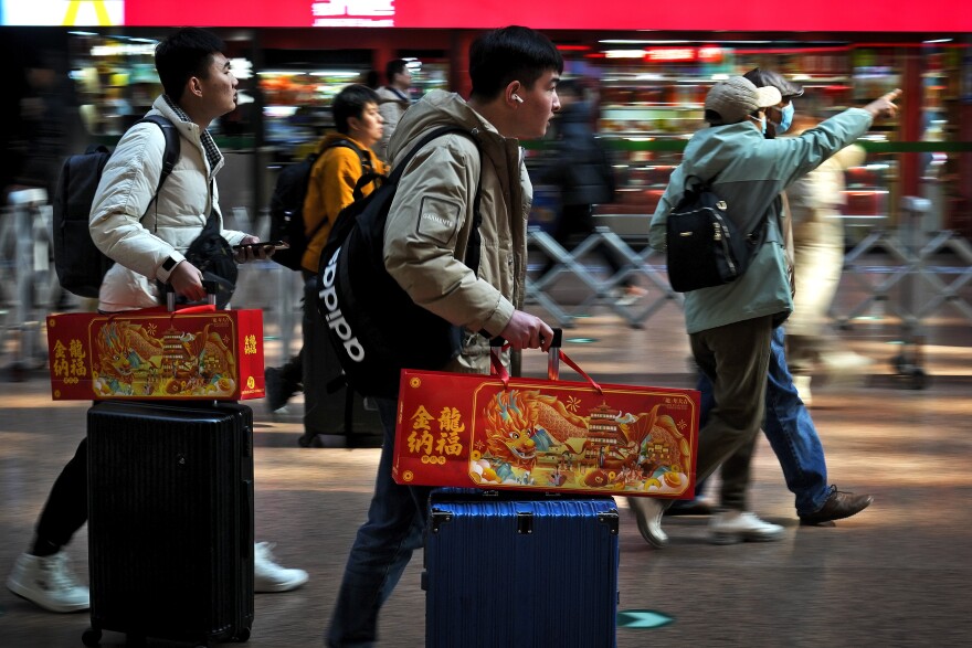 Travelers with their luggage and Lunar New Year goodies arrive at a departure hall to catch their trains at the West Railway Station in Beijing, Saturday, Feb. 3, 2024. Millions of Chinese are expected to travel during the Lunar New Year holiday period. (AP Photo/Andy Wong)