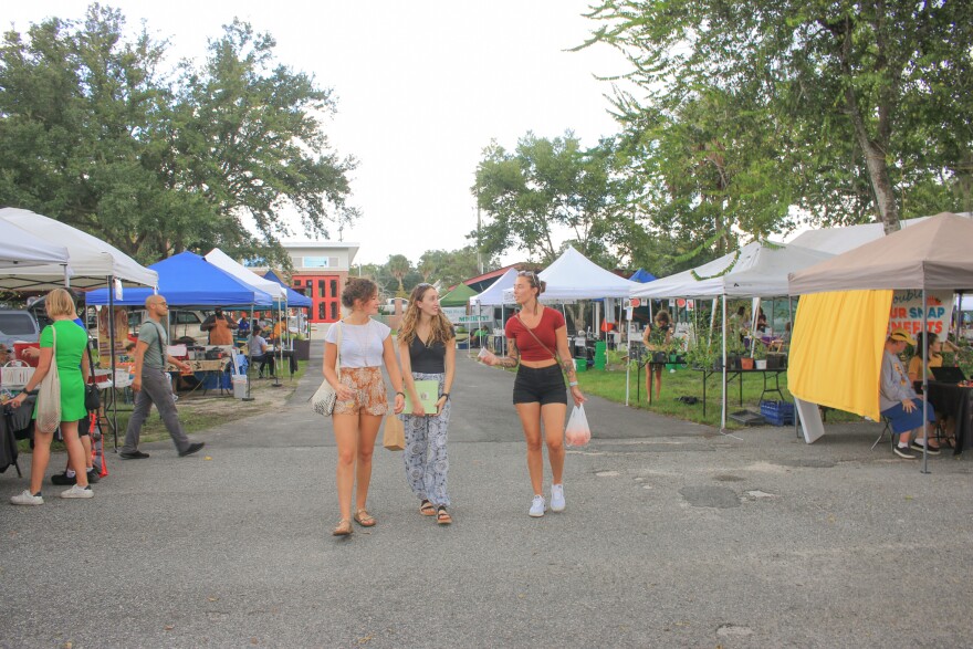 Friends make their way out of the Gainesville Farmers Market at Heartwood and South Main Station after buying fresh produce, September 16, 2022. (Ismara Corea/WUFT News)