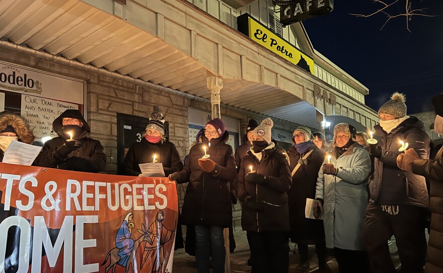 People hold candles and a banner at a Jan. 27, 2026, vigil outside El Potro Mexican Restaurant in downtown Brainerd.