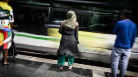 A young woman wears an Abaya (C) as she stands on a street in Nantes, western France.