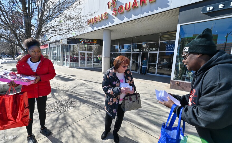 Aniyah Taylor and Sharee Clark, from the True Love Movement, give a Valentine to Linda Byrnes while passing out Valentine's Day cards as part of their project.
