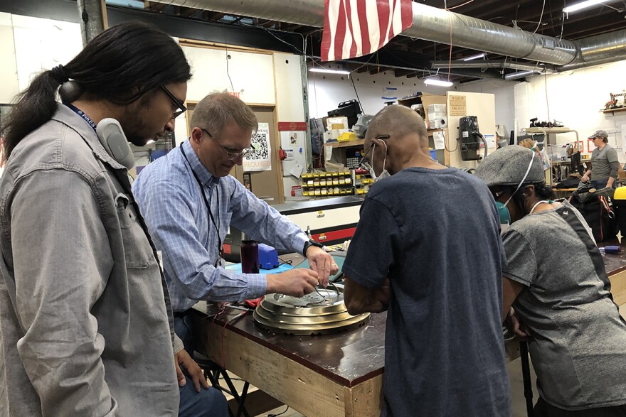 Volunteers help to fix a broken light fixture at a Repair Café in Colorado Springs, Colorado