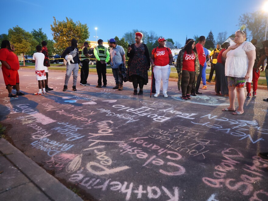 The names of the victims and messages of healing written in chalk at a makeshift memorial outside of the Tops supermarket in Buffalo, N.Y., on Sunday, one day after a gunman killed 10 people and injured 3 others.