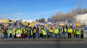 people wave signs on a picket line