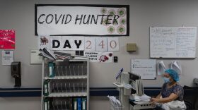 A medical staff member works on a computer as the number on the wall indicates the days since the hospital opened its COVID-19 unit at United Memorial Medical center in Houston, Texas.