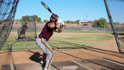 Man in baseball uniform prepares for pitch