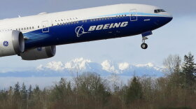 A Boeing 777X takes off on its first flight with the Olympic Mountains in the background at Paine Field in Everett on Jan. 25, 2020. Boeing said Wednesday it lost $8.4 billion in the fourth quarter on weaker demand for planes during the pandemic. 