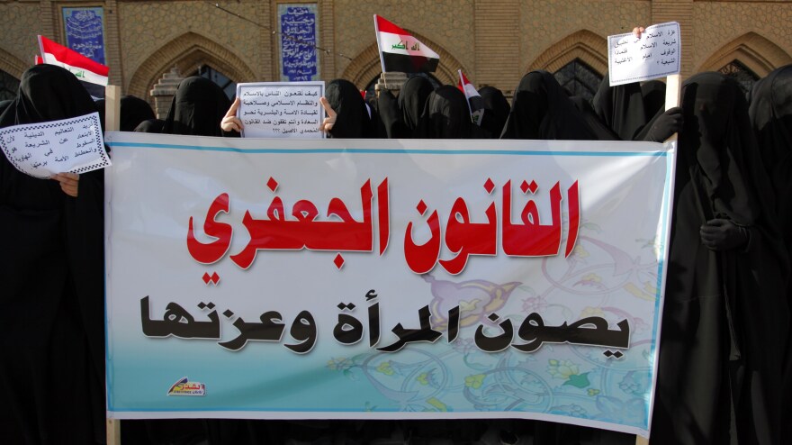 Iraqi women in Najaf hold up a placard in support of the Jaafari law in March. The law is based on the principles of the Jaafari school of Shiite religious jurisprudence. It prohibits Muslim men from marrying non-Muslims and lowers the marriage age to 9 for girls and 15 for boys.