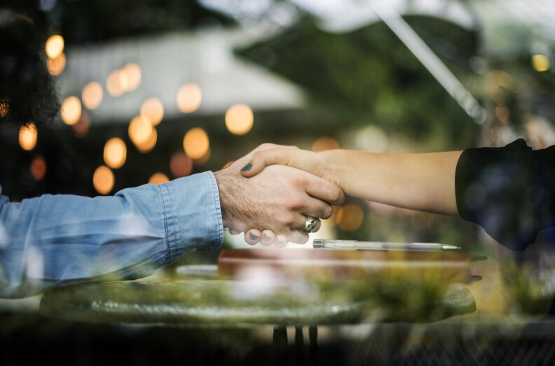 Two people shake hands.