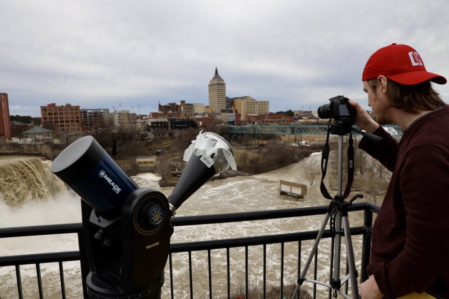 Ben Bodner of Rochester sets up his camera and his father's telescope on the High Falls viewing platform. His parents were visiting from out of town.
