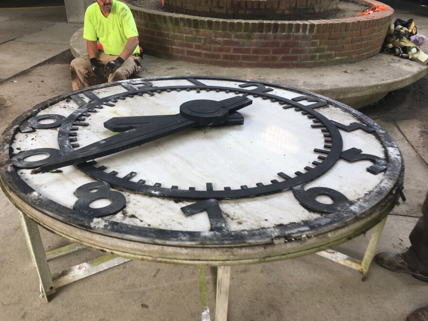 Workers remove this historic clock from the Town Center garage that has been there since the early 1970s.