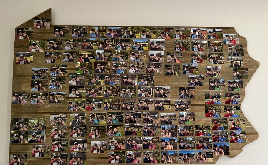 A map of Pennsylvania covered in photos of a man and a woman at each state park.