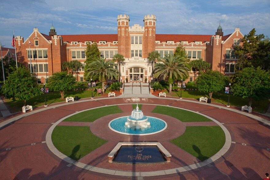 A large, brick building with a fountain in front of it