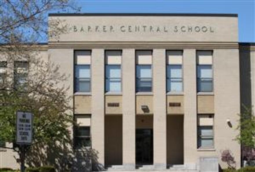 A gray school building that says, "BARKER CENTRAL SCHOOL" along the top front.