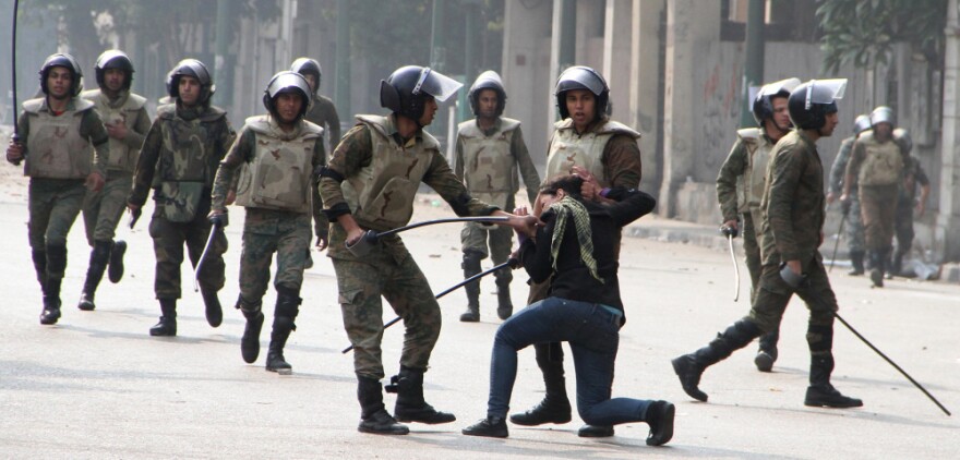 Egyptian army soldiers arrest a woman protester during clashes with military police near Cairo's Tahrir Square.