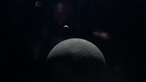 View of the moon in the foreground and the Earth in the distance