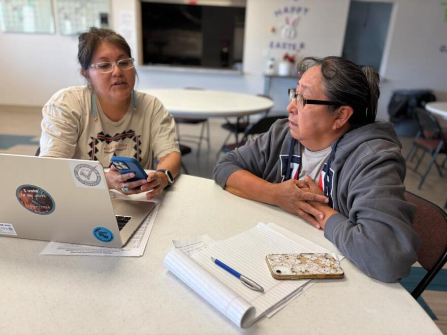 After some confusion during the 2024 election, Arizona Native Vote’s Jayne Parrish, left, helps Navajo Nation resident Betty John figure out where she should go to cast her ballot for the upcoming midterms. (Peter O’Dowd/Here & Now)