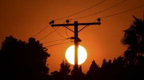 The sun sets behind power lines in Los Angeles in September.