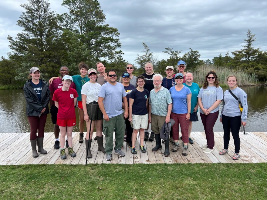 Participants of the 2023 inaugural mid-Atlantic Marine Bioinvasions Rapid Assessment Survey. Eighteen scientists and students stand in two rows in front of water.