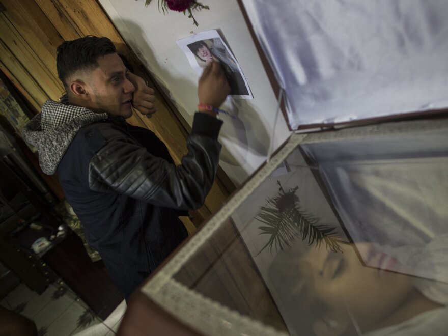 Rudy Fonseca, 29, cries next to the coffin containing the remains of his sister Kimberly Dayana Fonseca, 19, in Tegucigalpa, Honduras on Saturday. She was shot by gunmen who witnesses say were police.