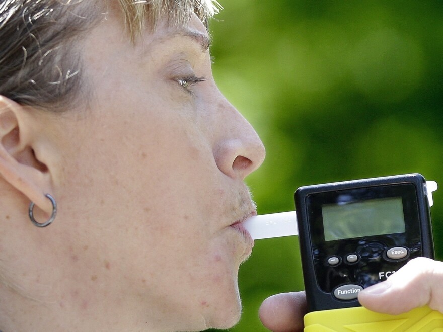 California Highway Patrol Sgt. Jaimi Kenyon blows into a alcohol breathalyzer during a demonstration of devices used to test drivers suspected of impaired driving May 2017, in Sacramento, Calif. Lawmakers and police are hoping new devices will be developed to effectively test for marijuana use by drivers.