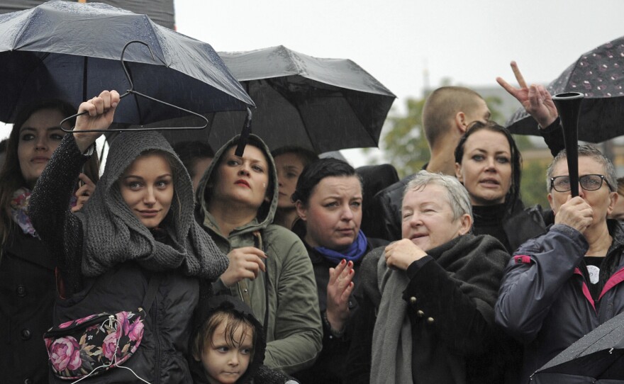 Massive protests were held in the rain in the streets of Warsaw, Gdansk, Wroclaw and elsewhere across the largely Catholic nation of Poland, as the conservative-controlled legislature considers an absolute ban on abortion. Here, women in Warsaw hold up a coat hanger, a symbol of dangerous and illegal abortions.