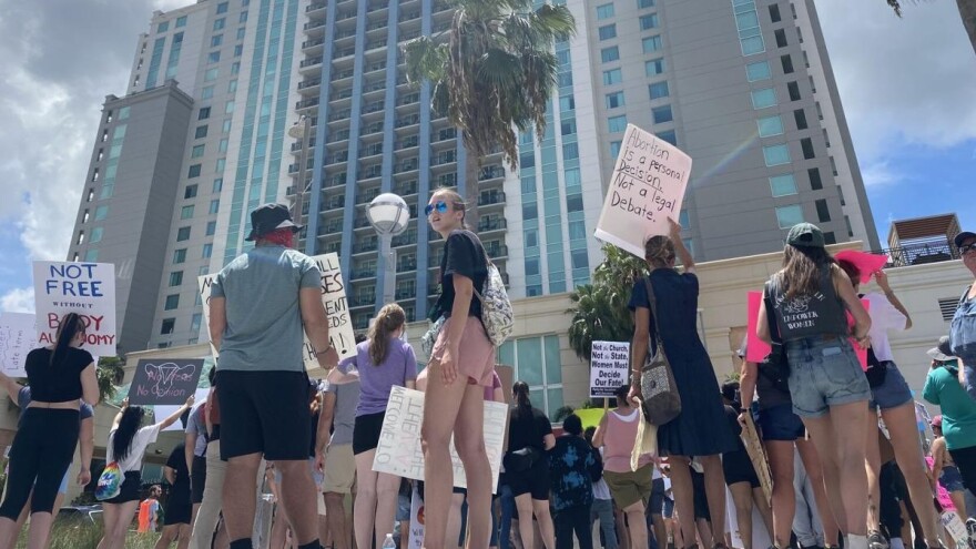 Protesters gather outside a Moms for Liberty event in Tampa.