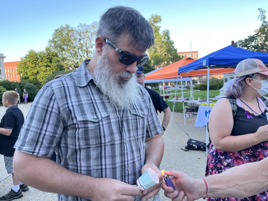 Concord resident Brian Harlow holds a candle during a vigil in front of the New Hampshire State House Wednesday for International Overdose Awareness Day.