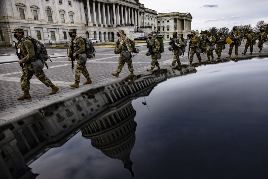 Virginia National Guard soldiers march across the east side of the U.S. Capitol on their way to their guard posts on Jan. 16, 2021. After the riots at the U.S. Capitol Building, the FBI warned of additional threats in the nation's capital and in all 50 states.